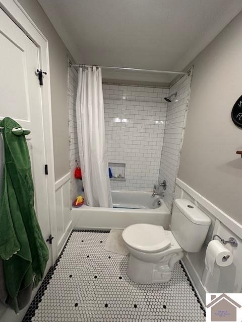 bathroom with shower / bath combination with curtain, tile patterned floors, and toilet