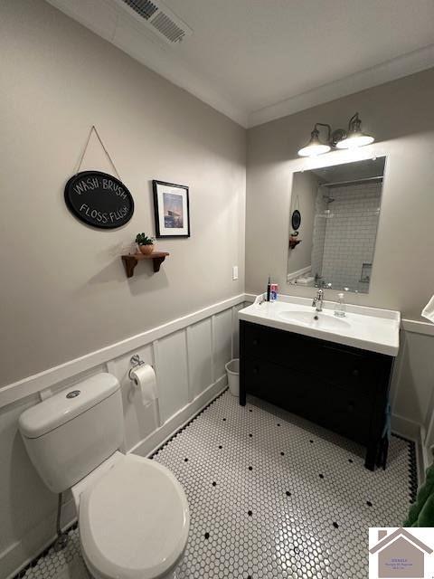 bathroom with crown molding, vanity, and toilet