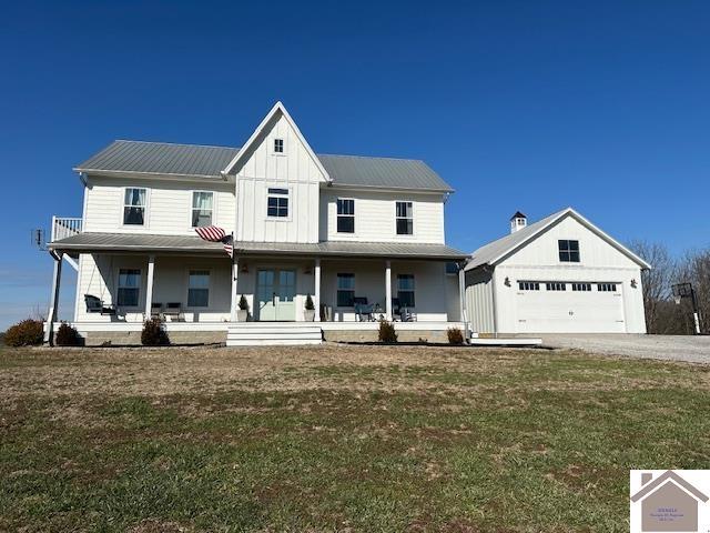 modern farmhouse with covered porch, a front lawn, and a garage