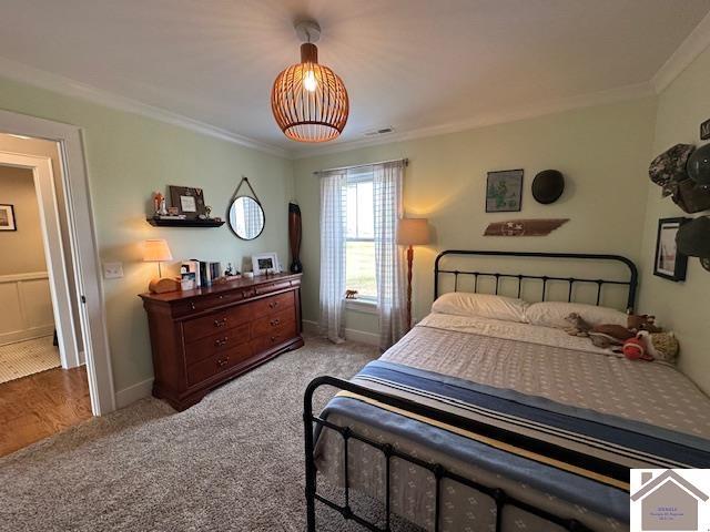 bedroom featuring carpet floors and crown molding