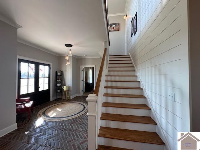 entryway featuring ornamental molding and french doors