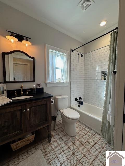 full bathroom featuring toilet, shower / tub combo with curtain, and vanity