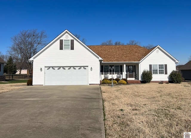 view of front of house with covered porch, a front lawn, and a garage