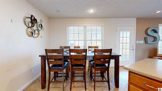 dining area with light tile patterned flooring and a textured ceiling