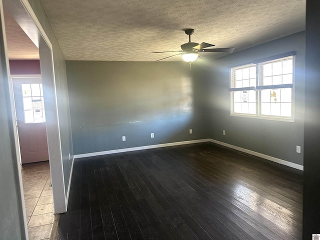 empty room featuring dark wood-type flooring, ceiling fan, and a textured ceiling