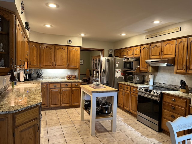 kitchen with light tile patterned flooring, appliances with stainless steel finishes, backsplash, and sink