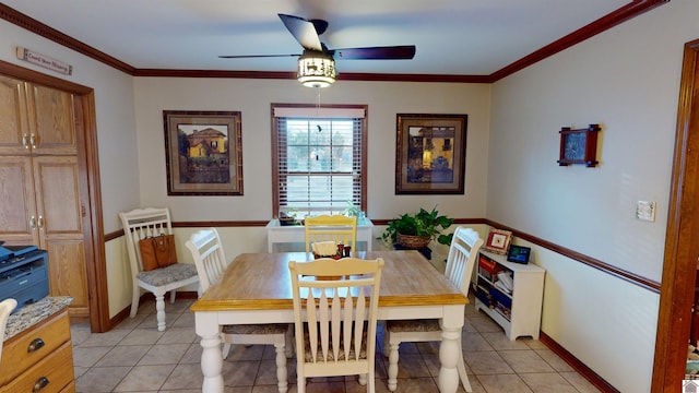 tiled dining space with ceiling fan and crown molding