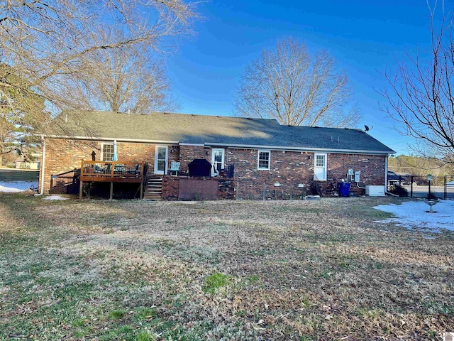 rear view of house with a wooden deck and a lawn