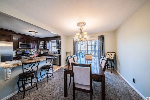 dining space with an inviting chandelier, carpet floors, and sink