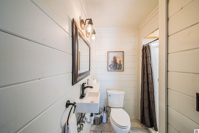 bathroom featuring a shower with shower curtain, wood walls, and toilet