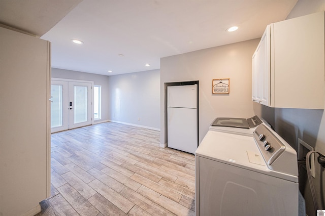 clothes washing area with independent washer and dryer, cabinets, french doors, and light hardwood / wood-style flooring