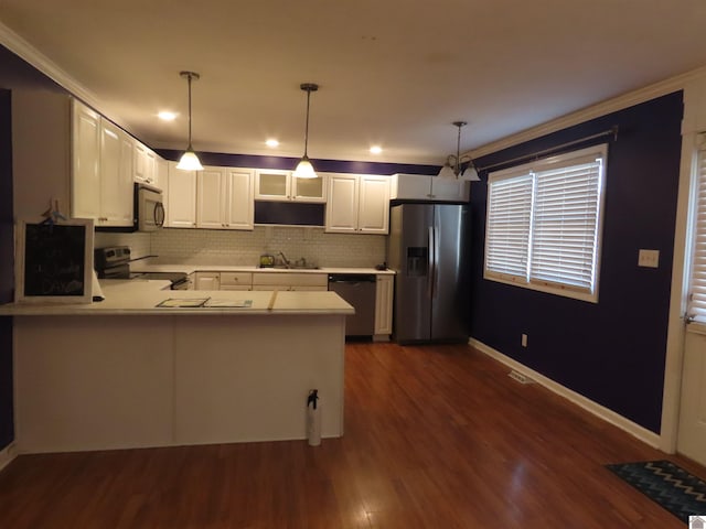 kitchen with sink, white cabinetry, kitchen peninsula, hanging light fixtures, and appliances with stainless steel finishes