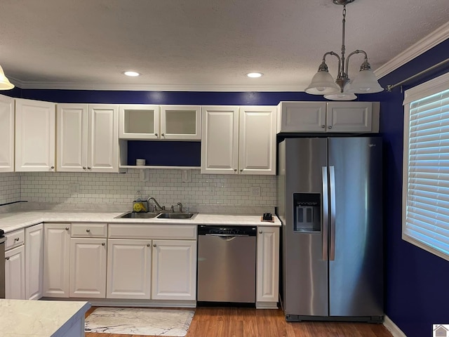 kitchen featuring sink, decorative light fixtures, white cabinets, and appliances with stainless steel finishes