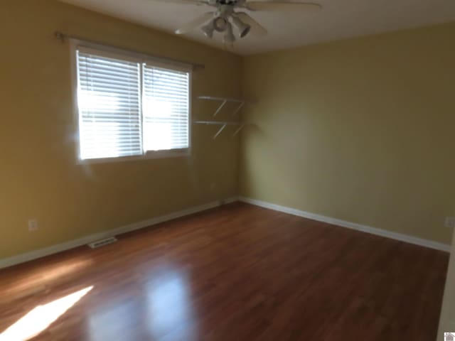 unfurnished room with ceiling fan and wood-type flooring