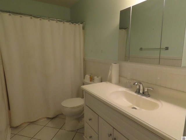 bathroom with toilet, vanity, and tile patterned floors