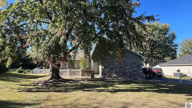 view of side of home with a yard