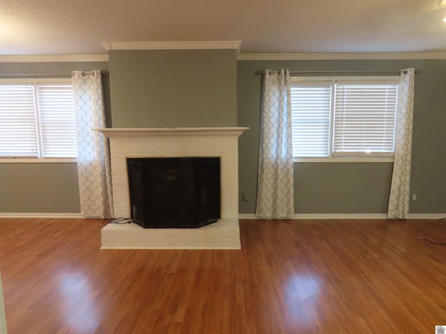 unfurnished living room featuring ornamental molding, a fireplace, and wood-type flooring