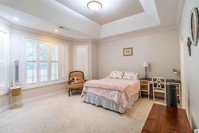 carpeted bedroom featuring a tray ceiling and ornamental molding