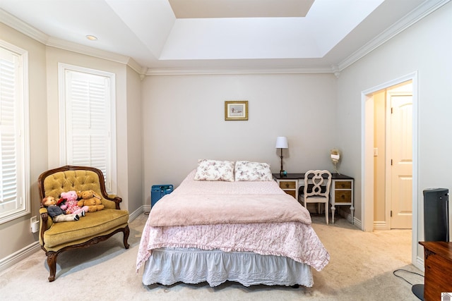 carpeted bedroom with ornamental molding and a tray ceiling