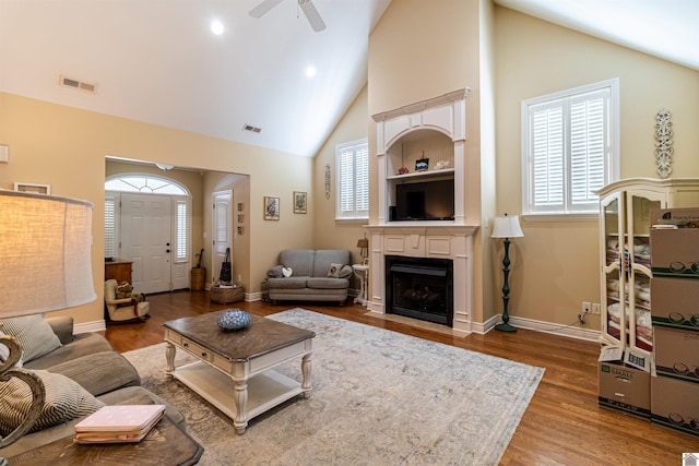 living room featuring hardwood / wood-style flooring, high vaulted ceiling, and ceiling fan