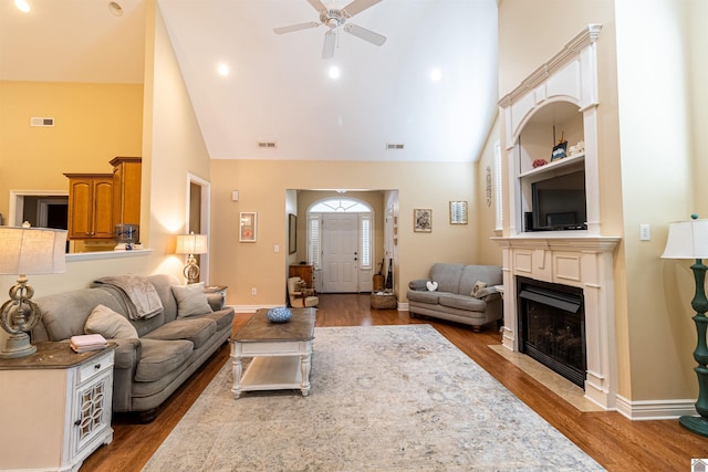 living room with hardwood / wood-style flooring, high vaulted ceiling, and ceiling fan