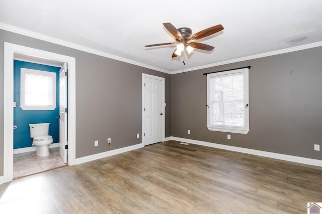 unfurnished bedroom featuring ensuite bathroom, ceiling fan, and crown molding