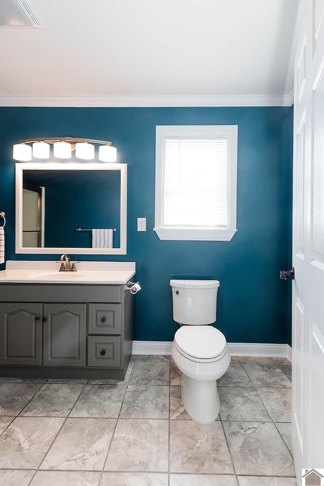 bathroom featuring toilet, vanity, and ornamental molding