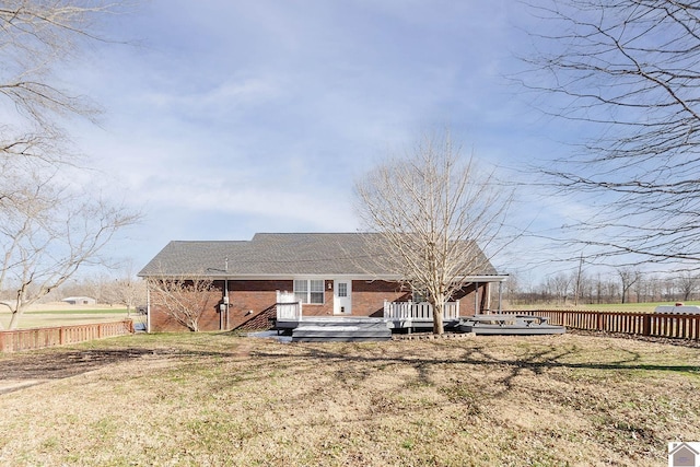 rear view of house featuring a yard and a wooden deck