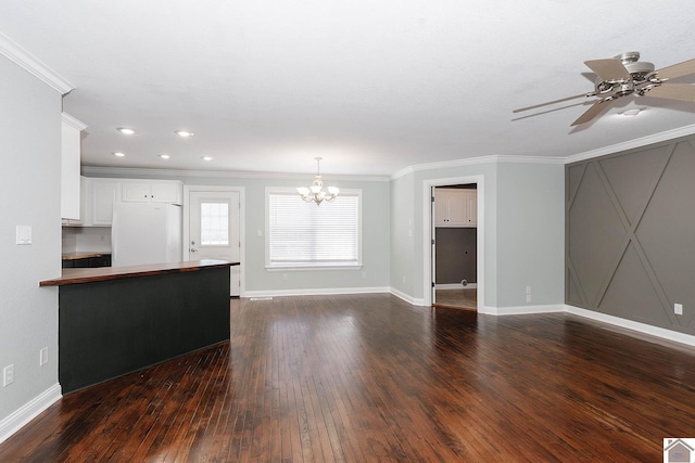 unfurnished living room with ceiling fan with notable chandelier, dark hardwood / wood-style flooring, and ornamental molding