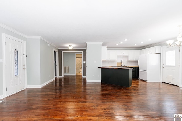 interior space with a notable chandelier, sink, crown molding, and dark hardwood / wood-style floors