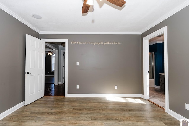 empty room featuring ceiling fan, wood-type flooring, and crown molding