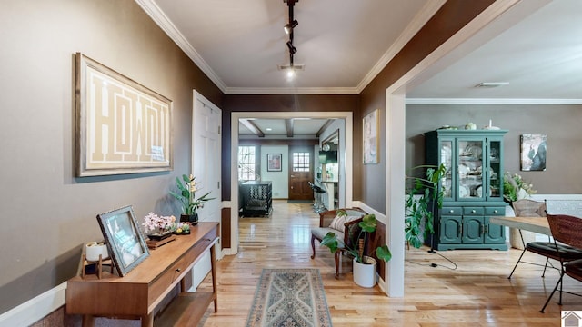 corridor featuring light hardwood / wood-style floors, track lighting, and ornamental molding