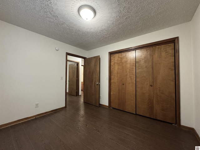 unfurnished bedroom with a closet, dark hardwood / wood-style floors, and a textured ceiling