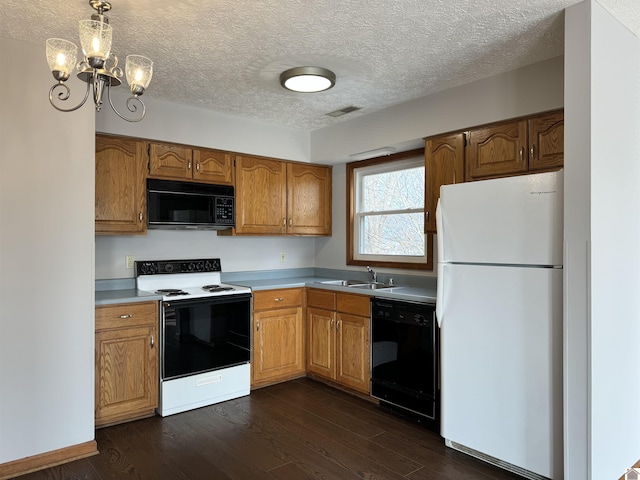 kitchen with decorative light fixtures, a notable chandelier, dark hardwood / wood-style floors, black appliances, and a textured ceiling