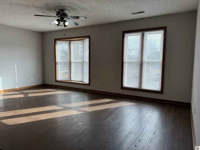 empty room featuring ceiling fan, dark hardwood / wood-style flooring, and a textured ceiling