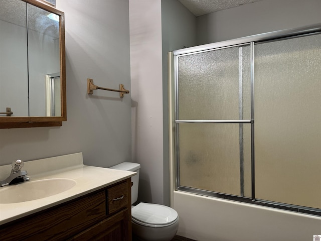 full bathroom with toilet, vanity, shower / bath combination with glass door, and a textured ceiling