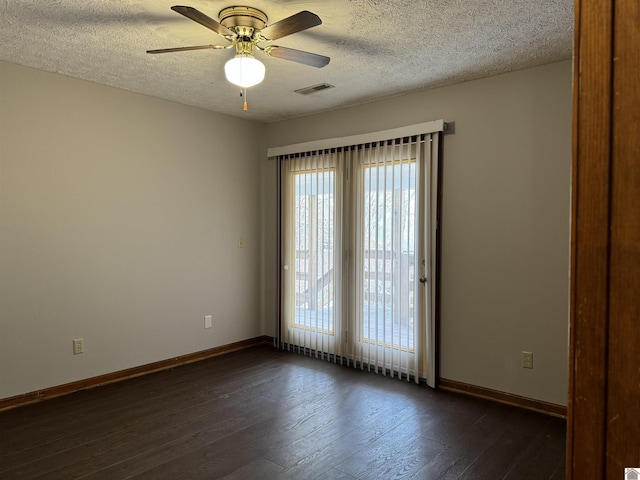 empty room with ceiling fan, a textured ceiling, and dark hardwood / wood-style floors