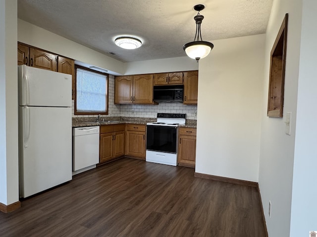 kitchen featuring dark hardwood / wood-style floors, backsplash, white appliances, a textured ceiling, and pendant lighting