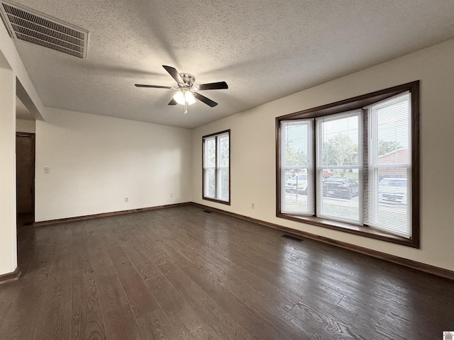 empty room featuring a textured ceiling, ceiling fan, and dark hardwood / wood-style floors