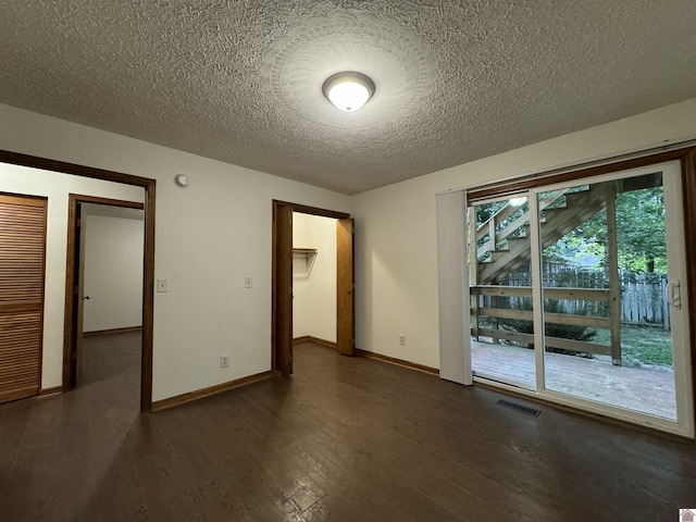 interior space with a textured ceiling, dark hardwood / wood-style floors, and access to outside