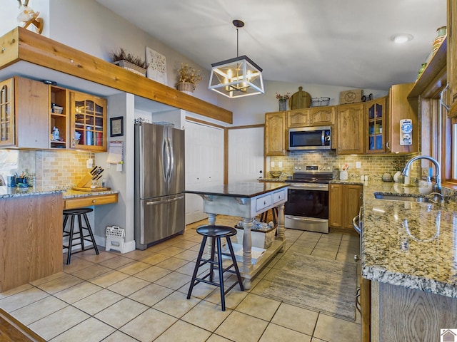 kitchen featuring decorative light fixtures, light tile patterned flooring, stainless steel appliances, light stone counters, and a chandelier