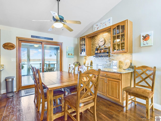 dining room with ceiling fan, lofted ceiling, and dark hardwood / wood-style floors