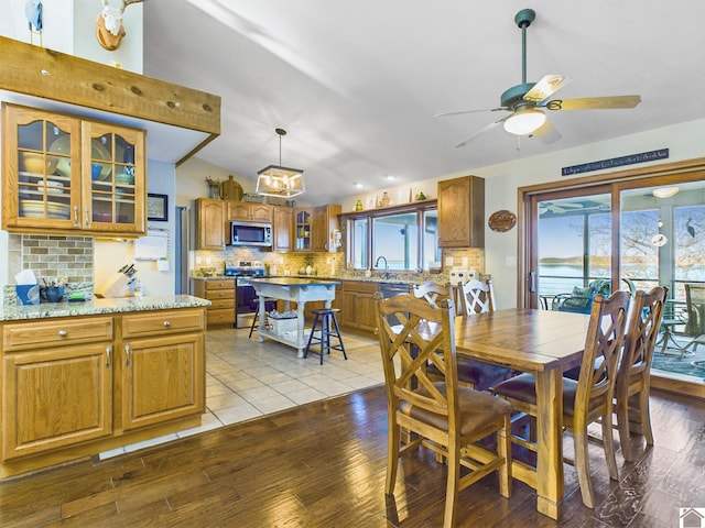 dining room featuring ceiling fan, sink, and light hardwood / wood-style flooring