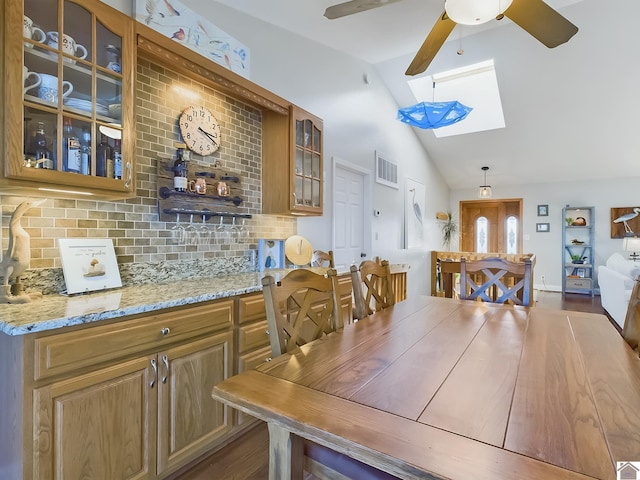 dining area with lofted ceiling with skylight