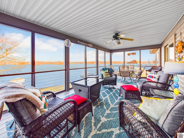 sunroom featuring a water view and ceiling fan