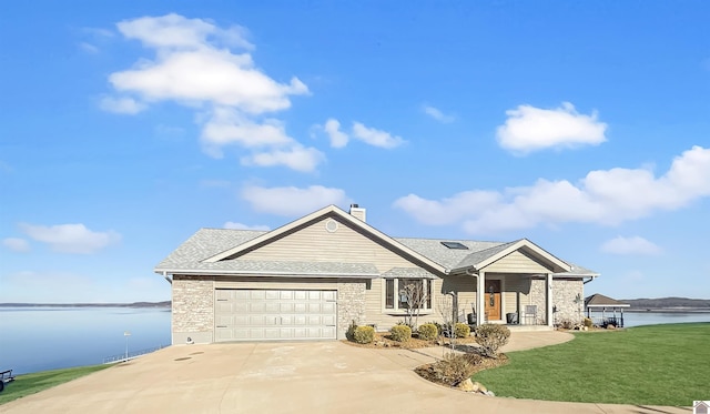 view of front of house featuring a water view, a front yard, and a garage