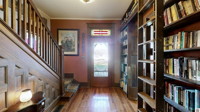 foyer entrance with hardwood / wood-style floors and ornamental molding