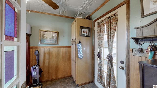 bathroom featuring crown molding and wood walls