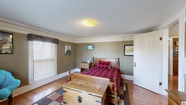 bedroom with dark hardwood / wood-style flooring and ornamental molding