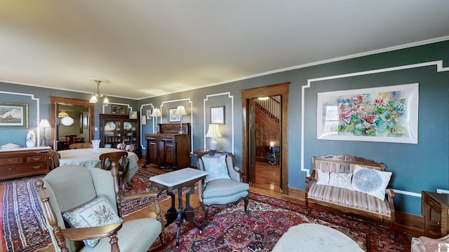 living room with hardwood / wood-style flooring, crown molding, and a chandelier